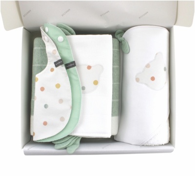 Conjunto de produtos de bebé com babete, toalha e manta em cores branco, verde e com padrão de bolas coloridas