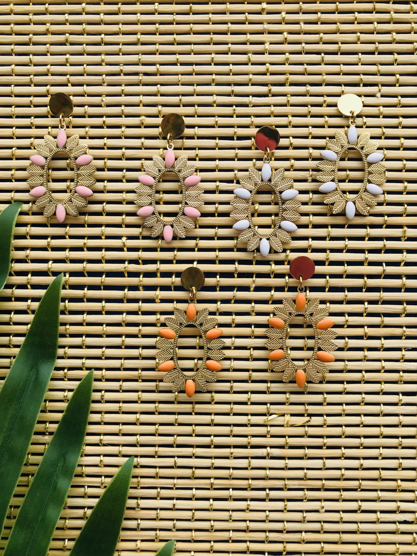 Brincos coloridos em bambu com folhas verdes ao lado