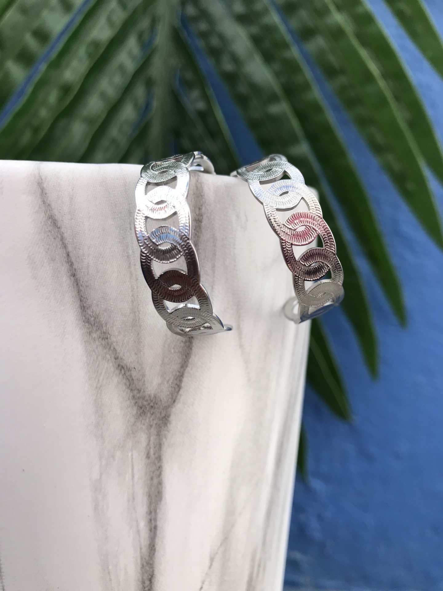 Brincos de argola prateados com padrão circular