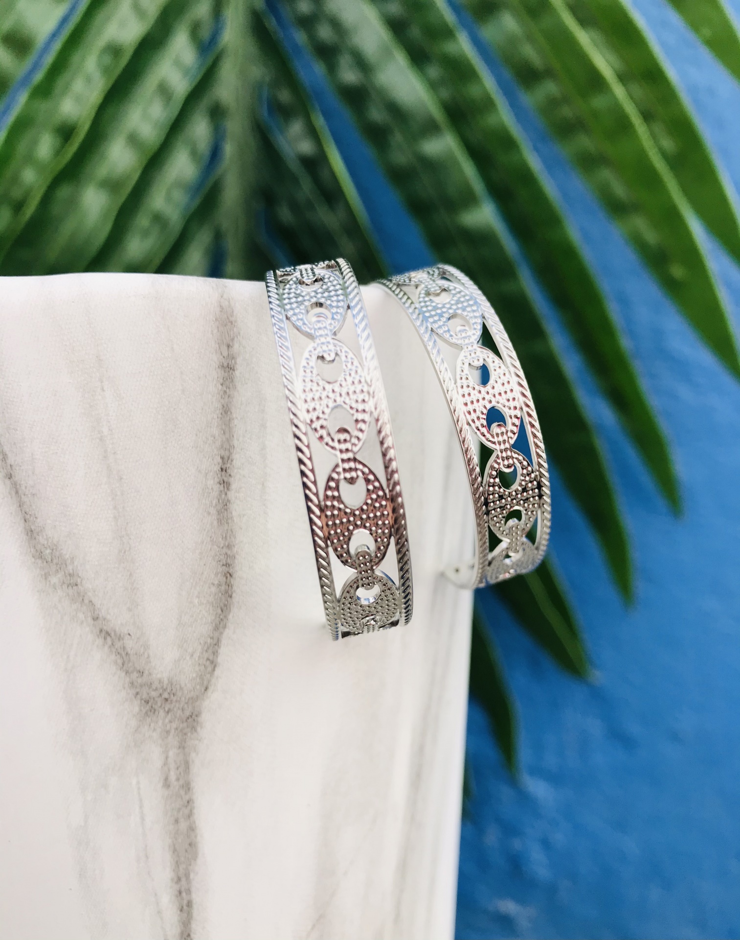 Par de pulseiras prateadas com padrões recortados