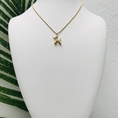 Colar dourado com pendente em forma de balão de animal num busto branco