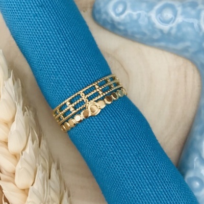 Anel dourado com três bandas distintas em tecido azul e fundo com espigas e decoração azul