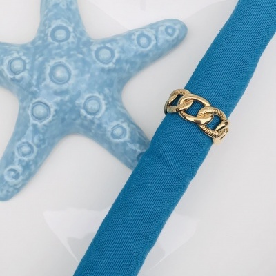 Anel dourado sobre tecido azul com estrela do mar azul clara décor