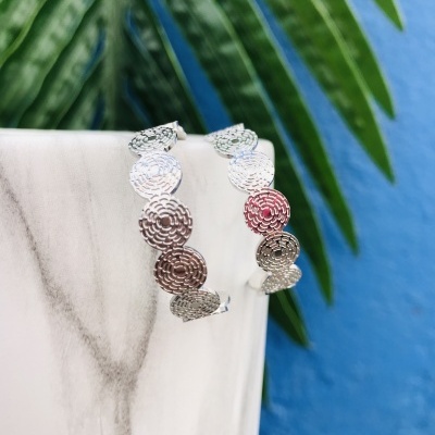 Brincos argola prateados com padrão circular texturizado