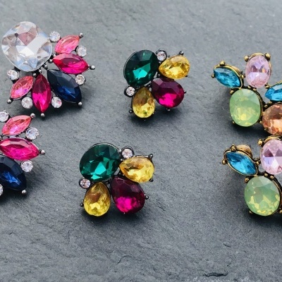 Brincos coloridos com várias pedras em fundo cinza