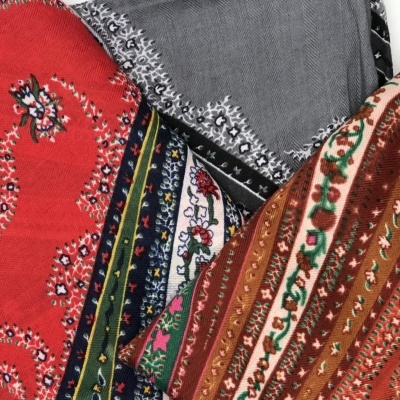 Três lenços com padrões paisley em vermelho, castanho e cinzento