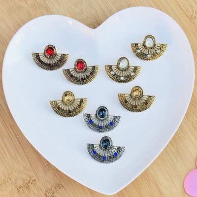 Brincos diversos em forma de leque sobre prato branco em forma de coração