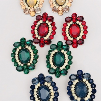 Oito brincos coloridos com pedras grandes e pequenas, organizados em pares sobre fundo branco.