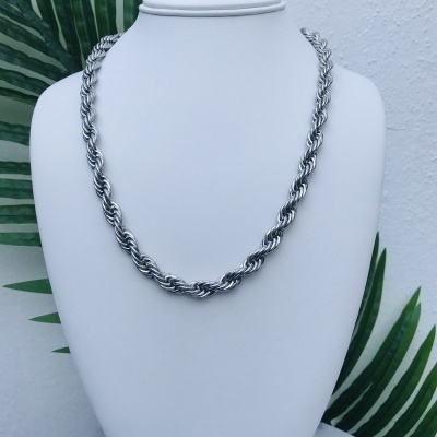 Colar de metal prateado com elos entrelaçados exposto em busto branco