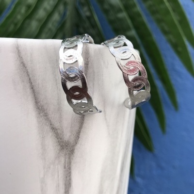 Brincos de argola prateados com padrão circular