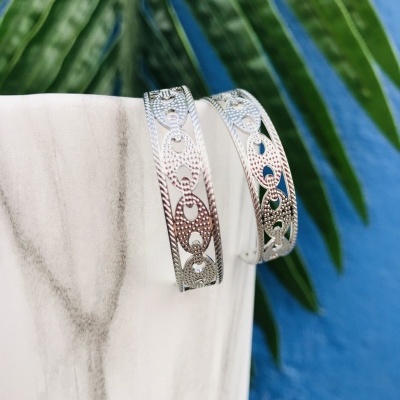 Par de pulseiras prateadas com padrões recortados