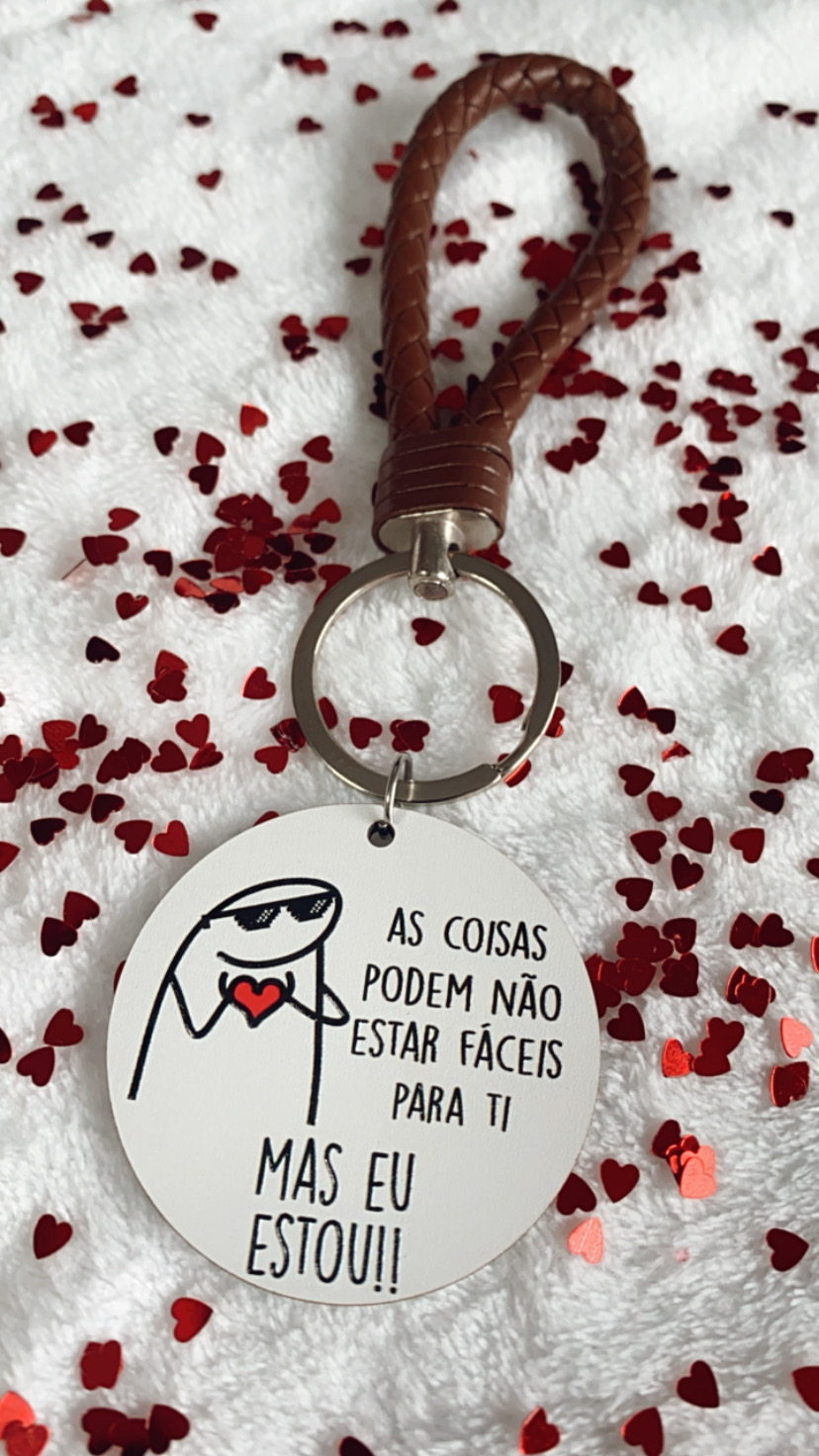 Porta-chaves com alça em couro castanho e pendente redondo com texto motivacional em português