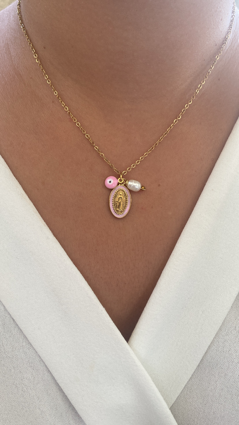 Colar dourado com medallhão rosa, conta rosa e pérola branca no decote branco