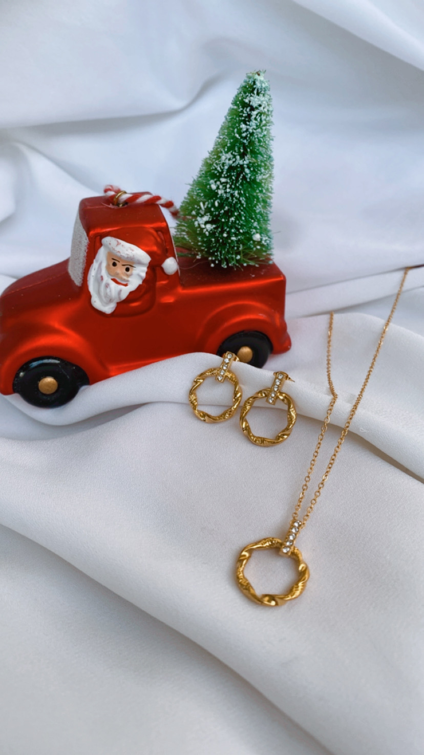 Miniatura de camião vermelho com Pai Natal, árvore de Natal verde e joias douradas sobre tecido branco