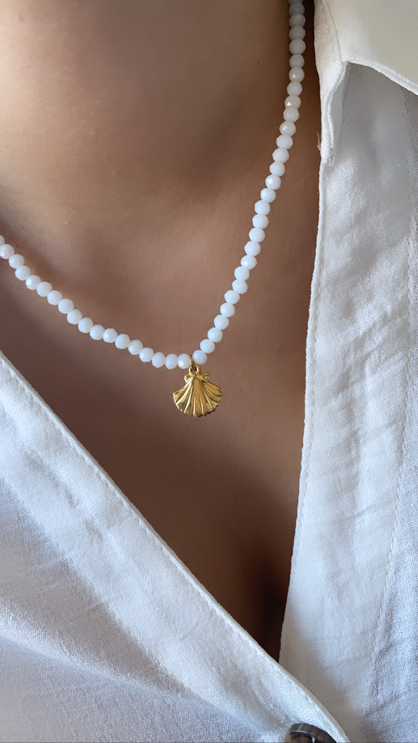 Colar branco com contas e pendente dourado em forma de concha