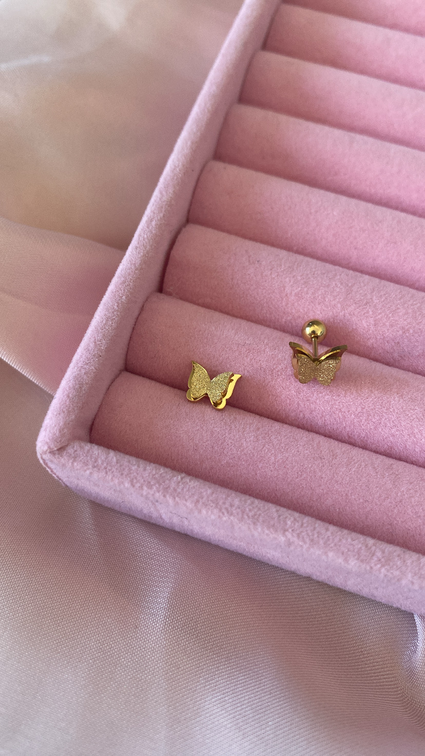 Par de brincos de borboleta em ouro numa caixa rosa almofadada