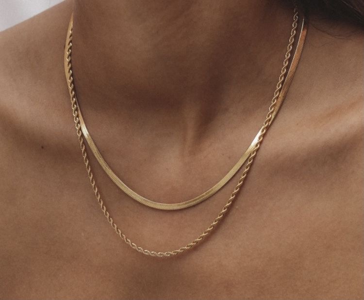 Colar dourado com duas correntes diferentes usadas no pescoço