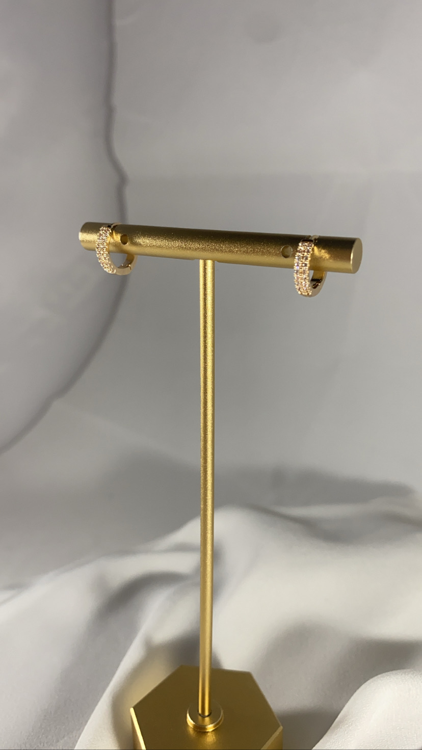 Brincos de argola dourados com pedras num suporte dourado