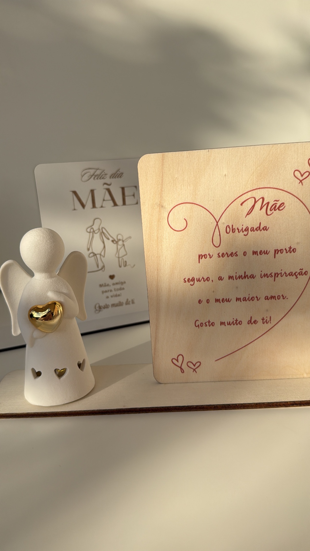 Estatueta de anjo branca com coração dourado e quadros com mensagens para mãe