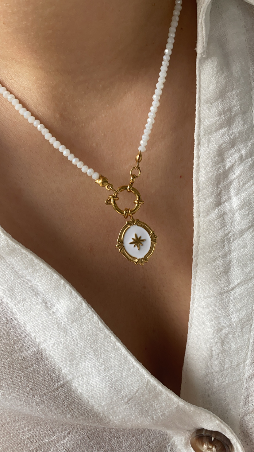 Colar de contas brancas com pendente dourado em forma de estrela