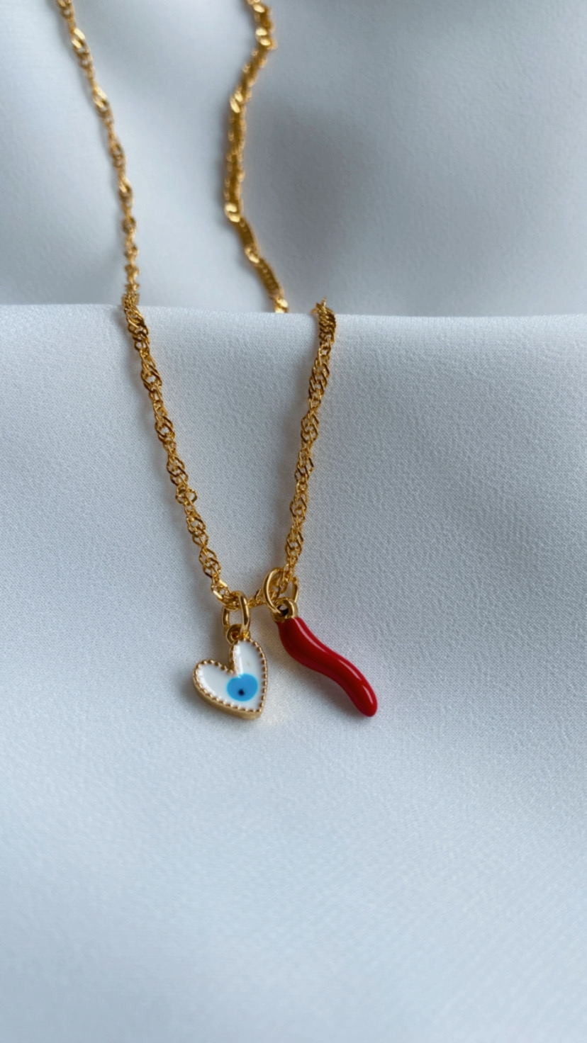 Colar dourado com pendentes de coração com olho azul e pimento vermelho