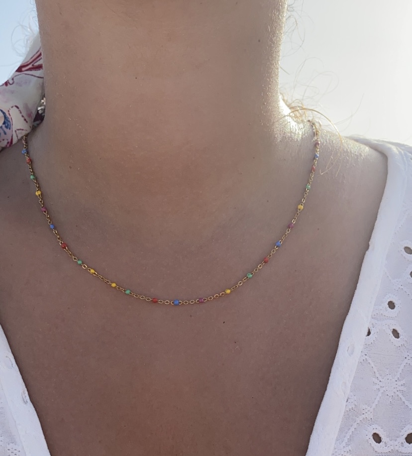 Colar colorido fino em metal dourado usado no pescoço