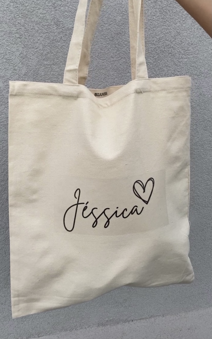 Saco de tecido bege com o nome Jéssica e um coração desenhado