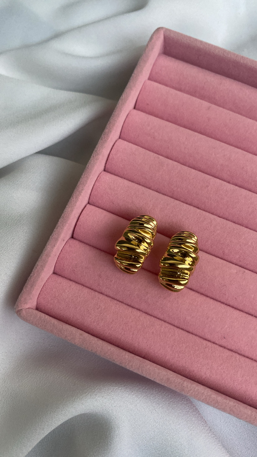 Brincos dourados ondulados em estojo de veludo rosa