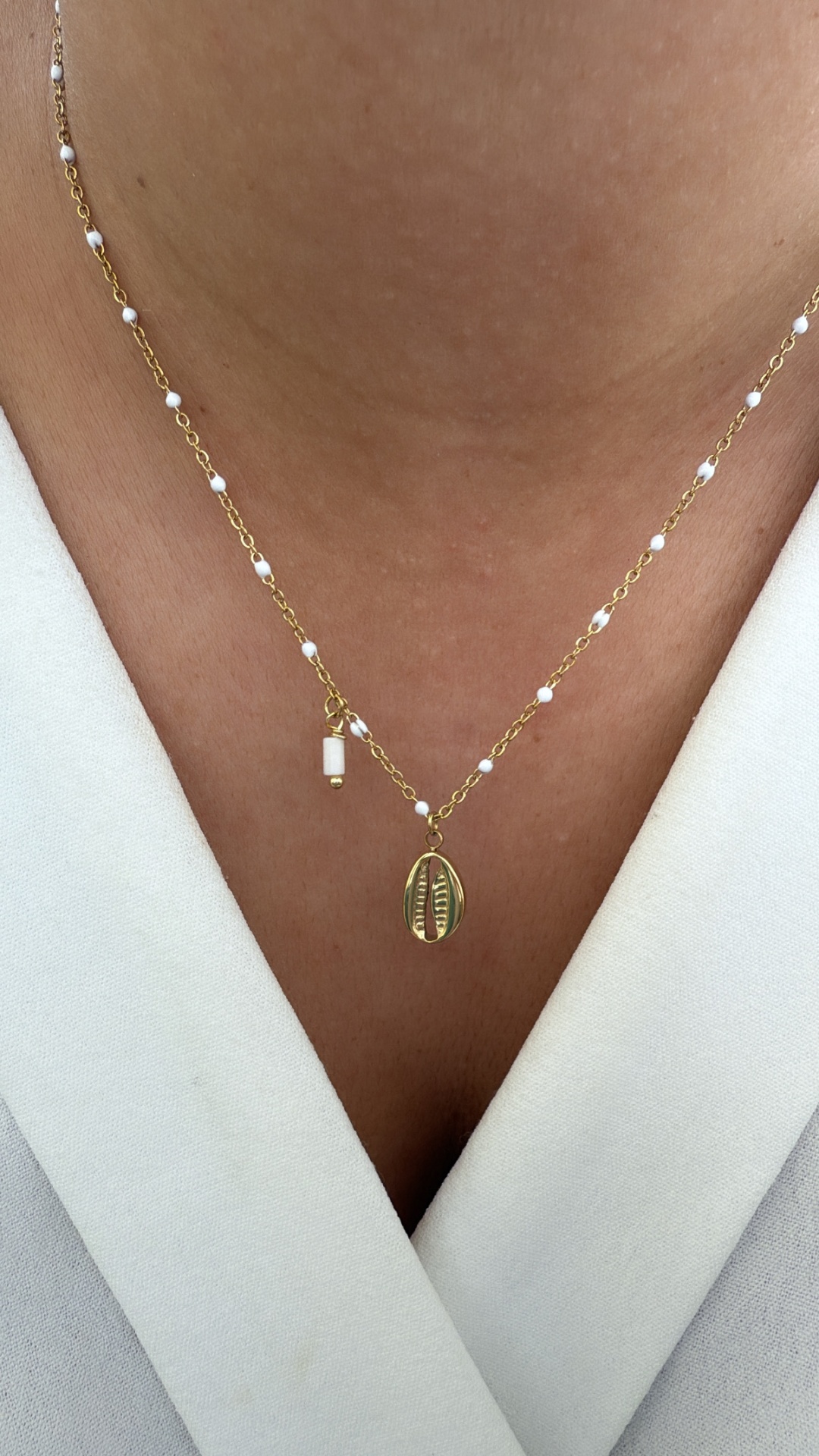 Colar dourado com pérolas e pendente de concha