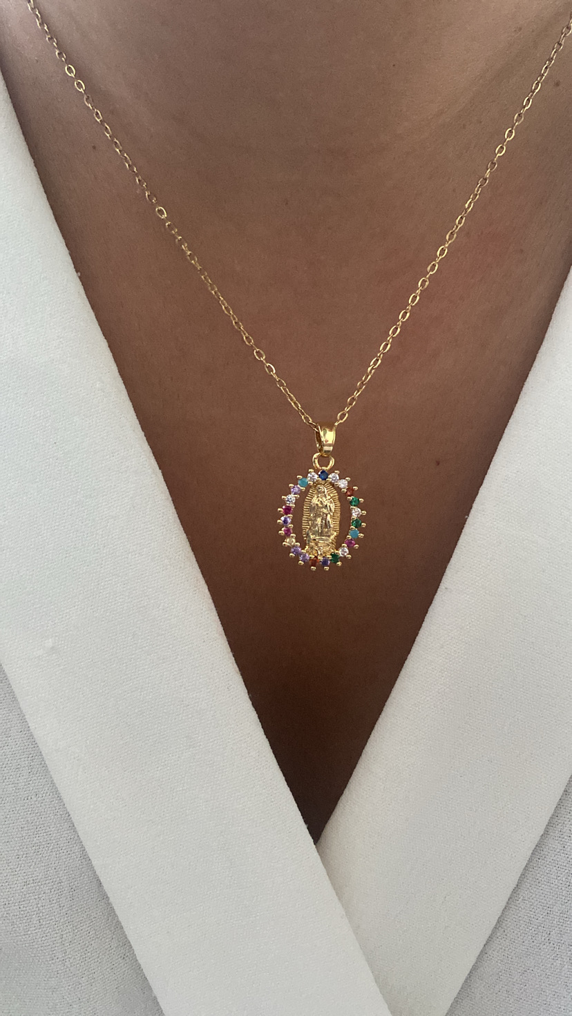 Colar dourado com pendente oval colorido num pescoço