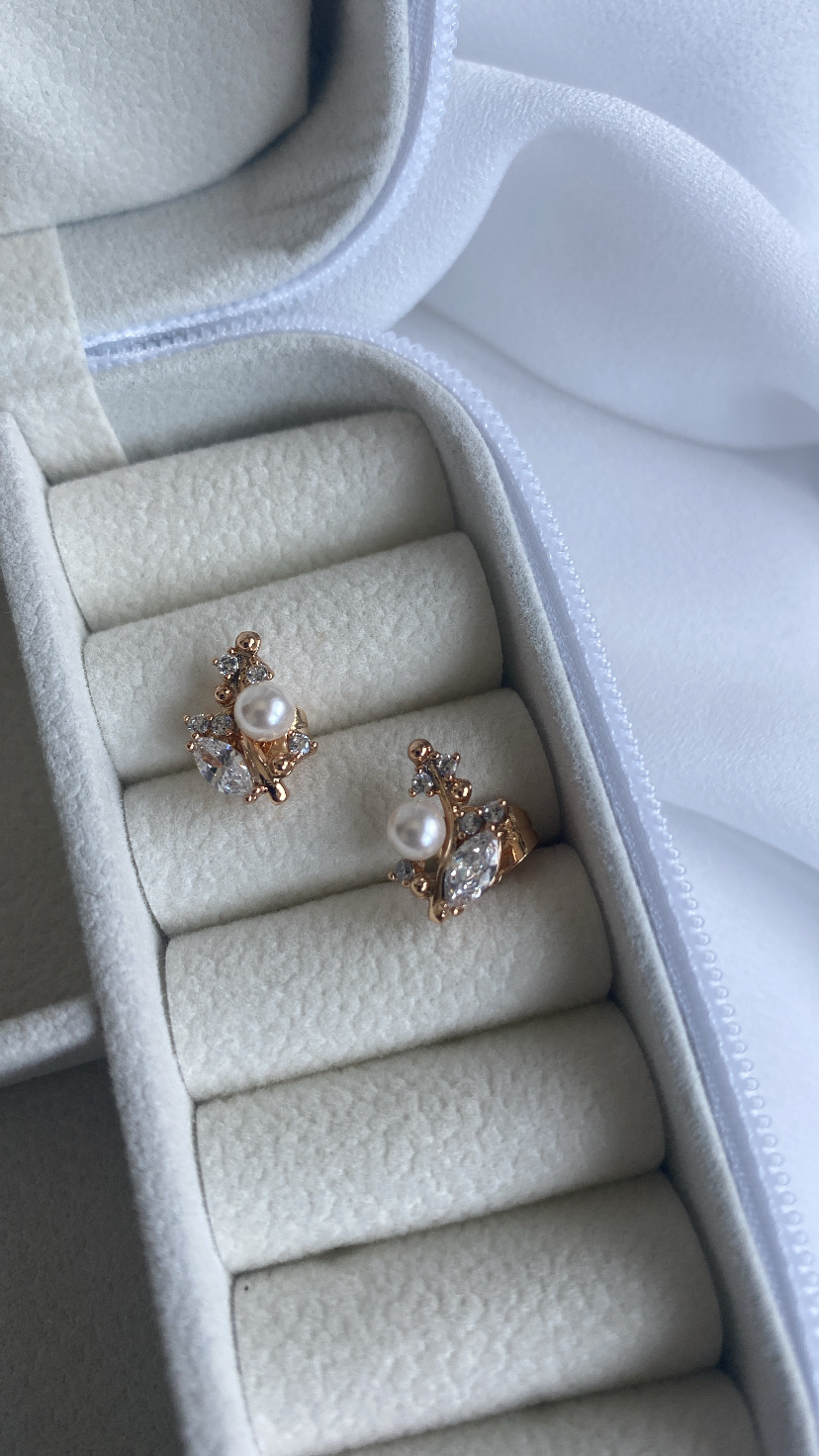 Brincos dourados com pérolas e pedras em caixa de veludo cinzenta clara