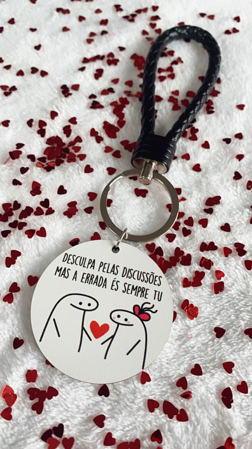 Porta-chaves com pendente redondo branco com desenho e texto em português sobre fundo branco com corações vermelhos