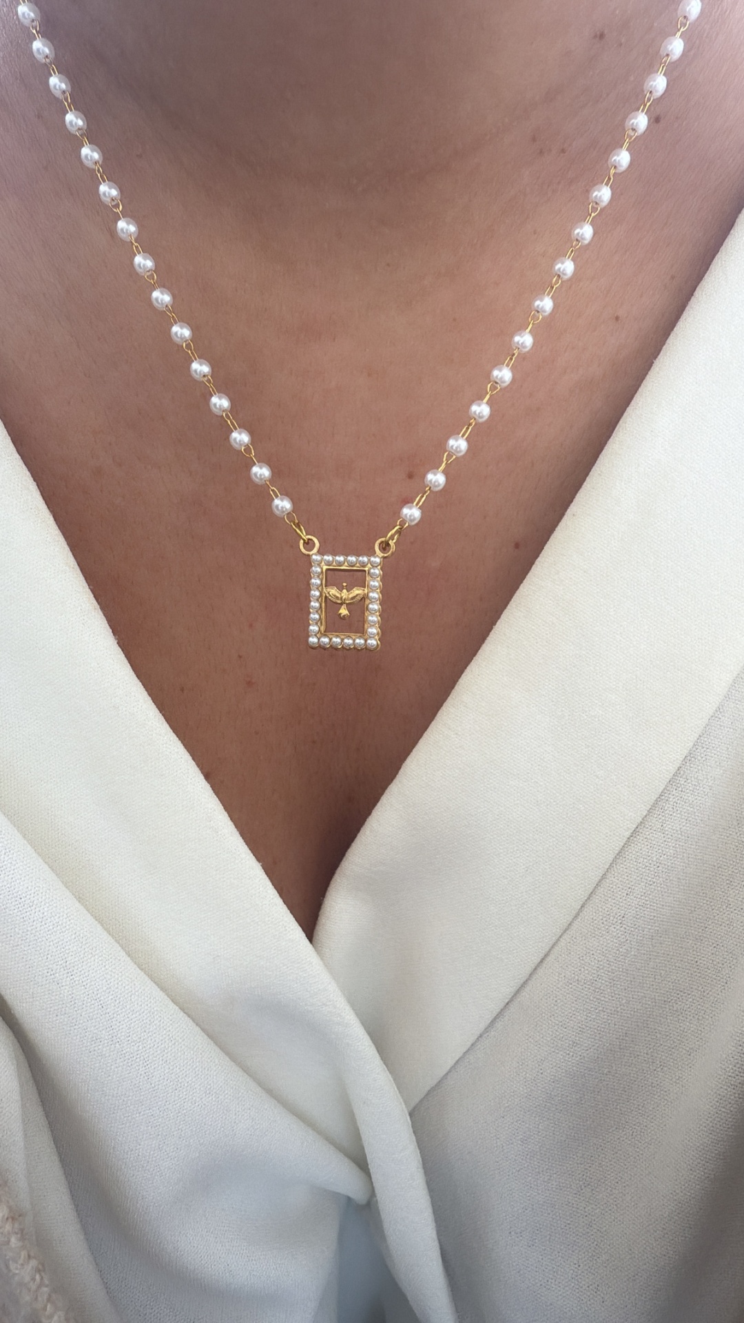 Colar com pérolas e pendente dourado retangular com anjo