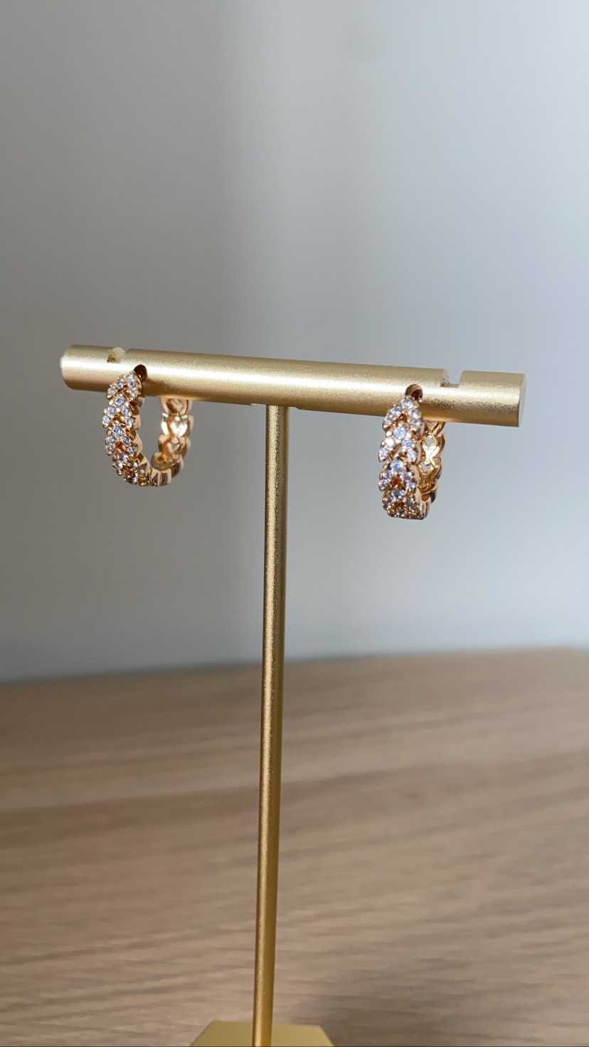 Brincos de argola dourados com pedras num suporte dourado