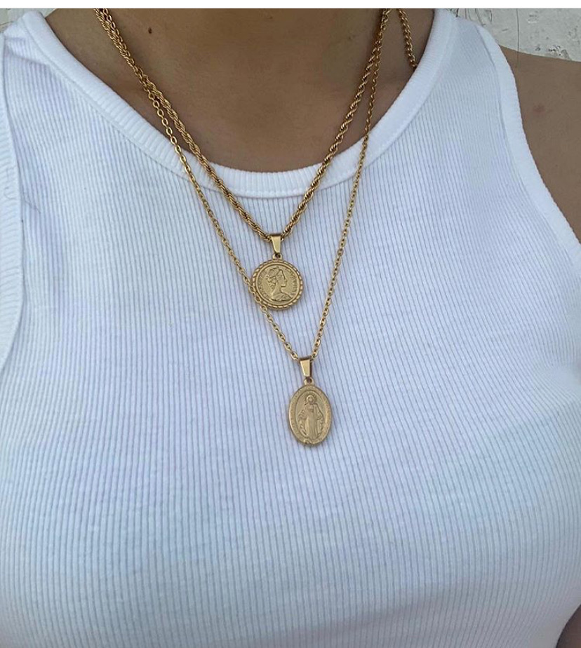 Colar dourado com dois pendentes redondos usado com t-shirt branca canelada.