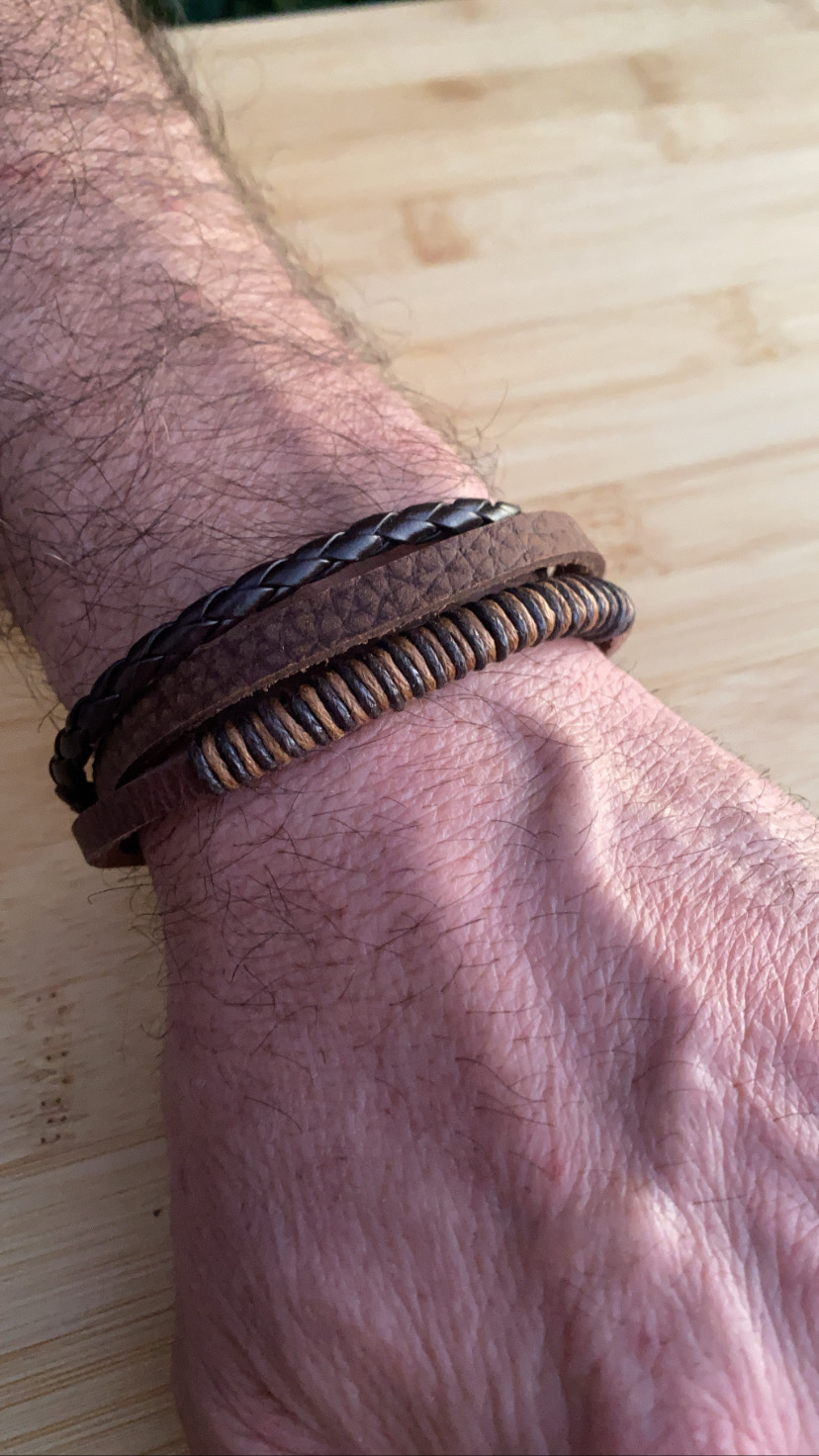 Pulseira masculina em couro castanho com várias tiras usadas no pulso