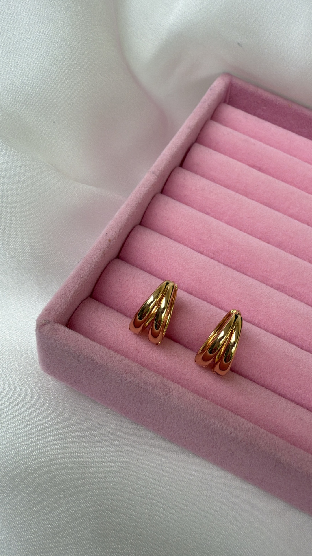 Brincos dourados em caixa de veludo rosa