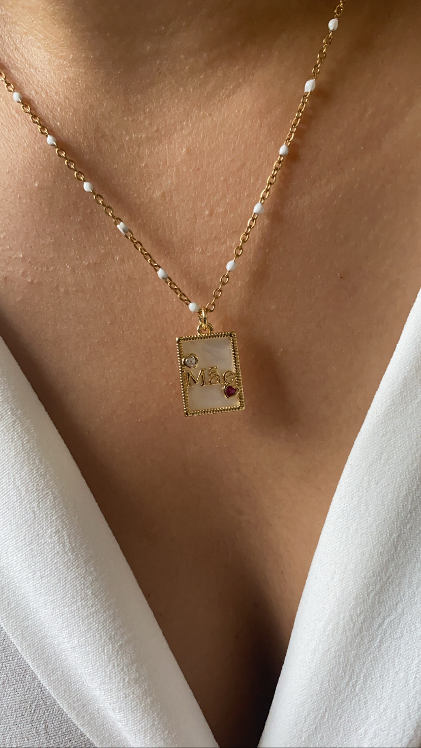 Colar dourado com pendente retangular e contas brancas
