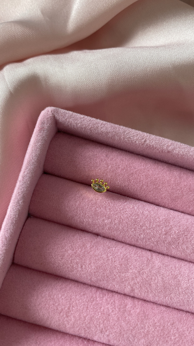 Anel dourado com pedra oval numa caixa de veludo rosa