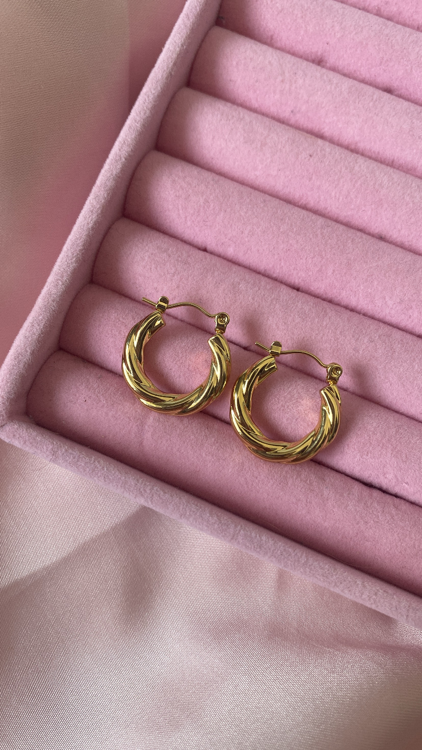 Brincos de argola dourados com textura torcional em caixa de veludo rosa