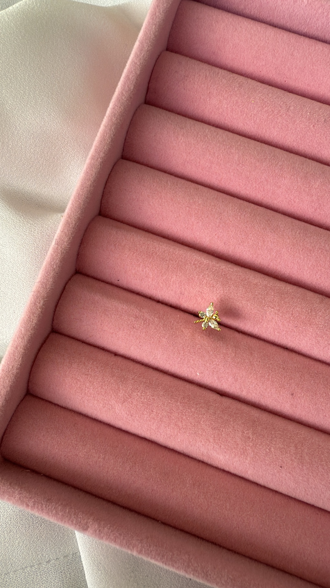 Anel dourado com pedras em caixa de veludo rosa