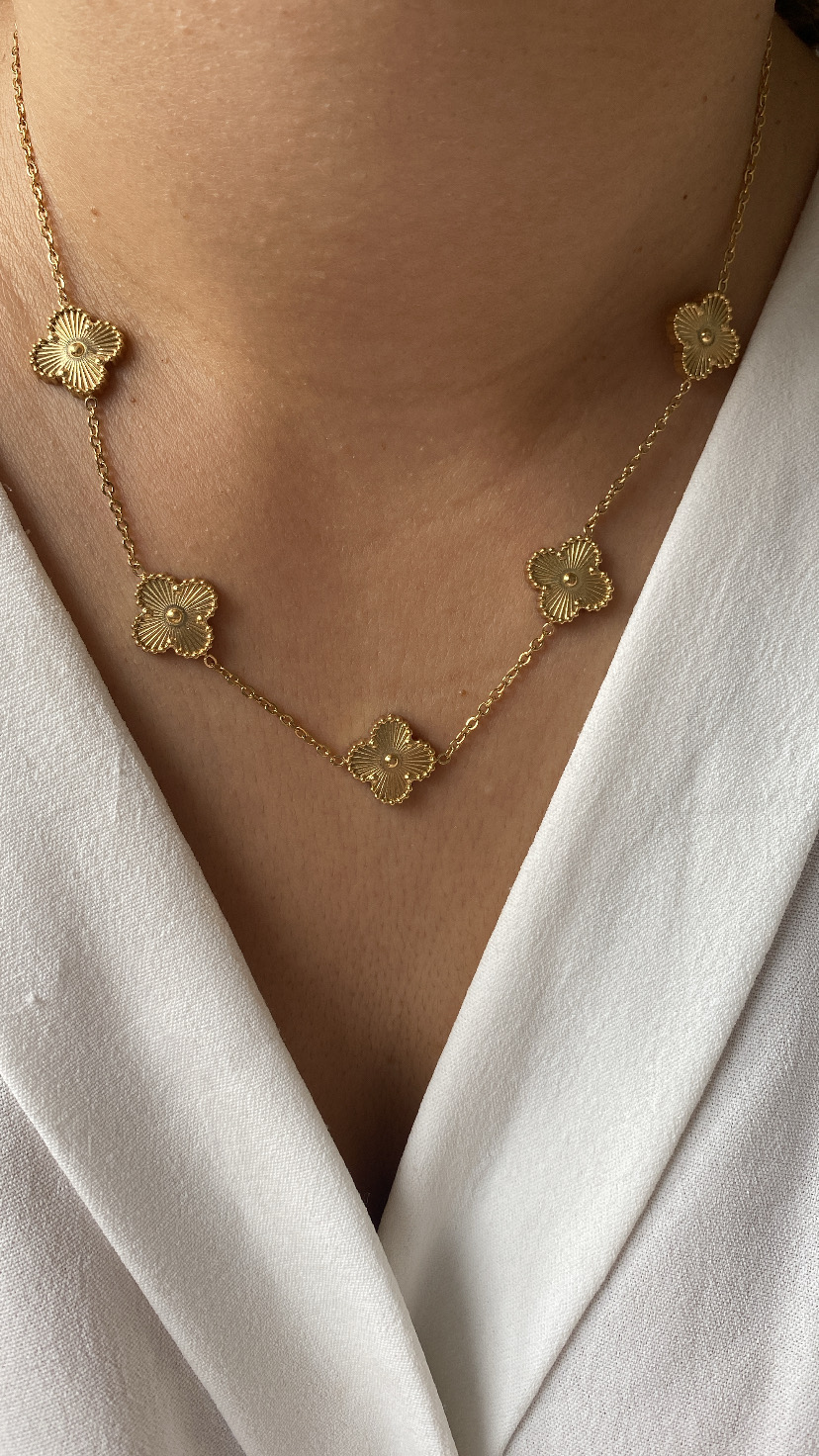 Colar dourado com pendentes florais em roupa branca