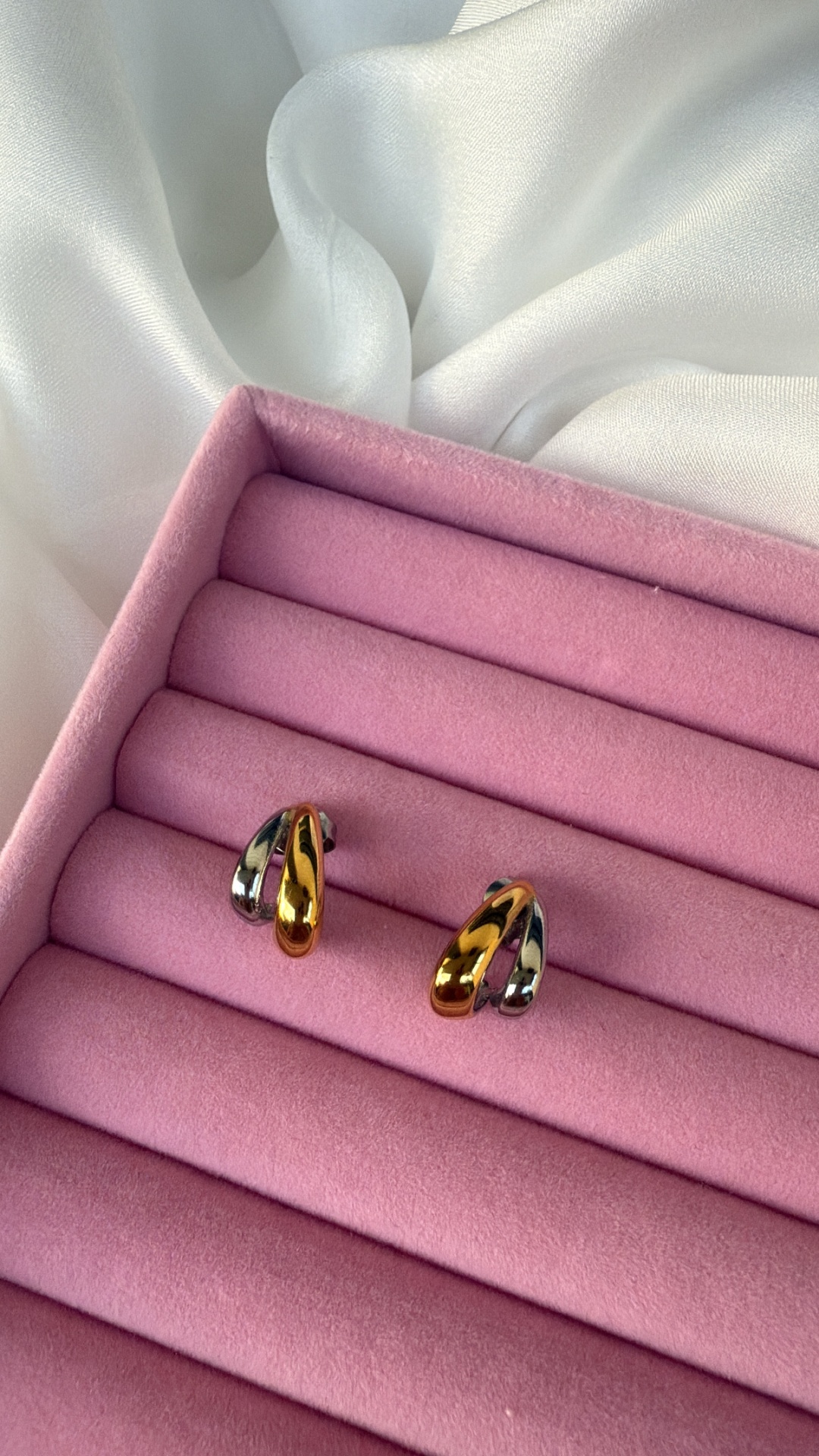 Brincos bicolores dourado e prateado em estojo rosa almofadado