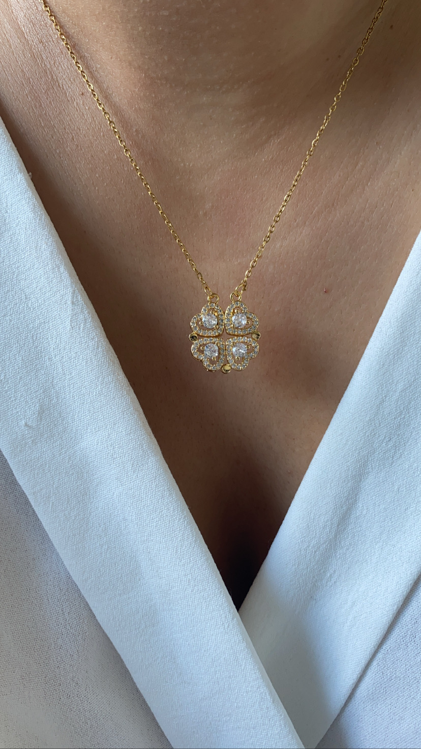 Colar dourado com pendente trevo e pedras brilhantes