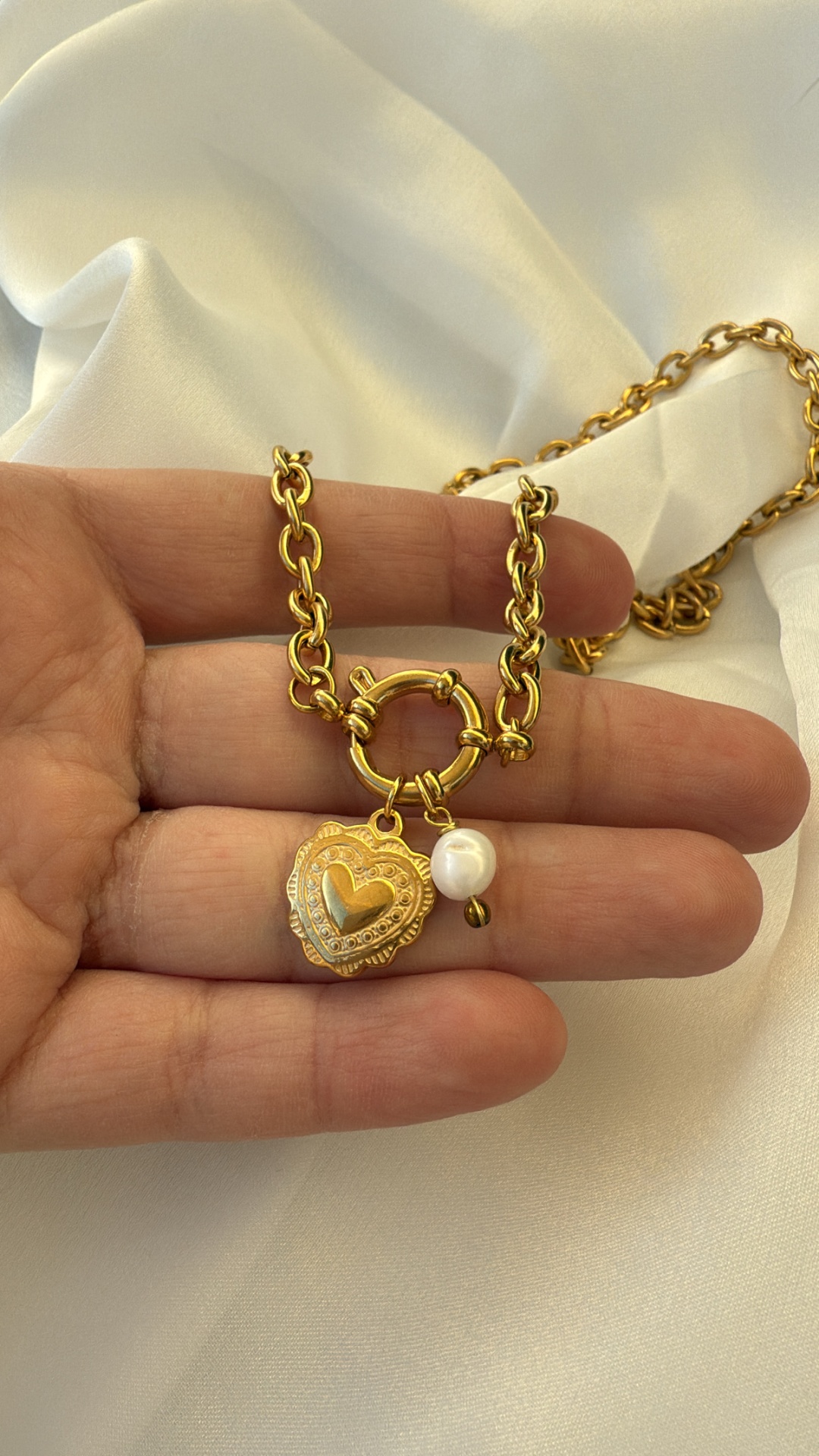 Colar dourado com pendente em forma de coração e pérola