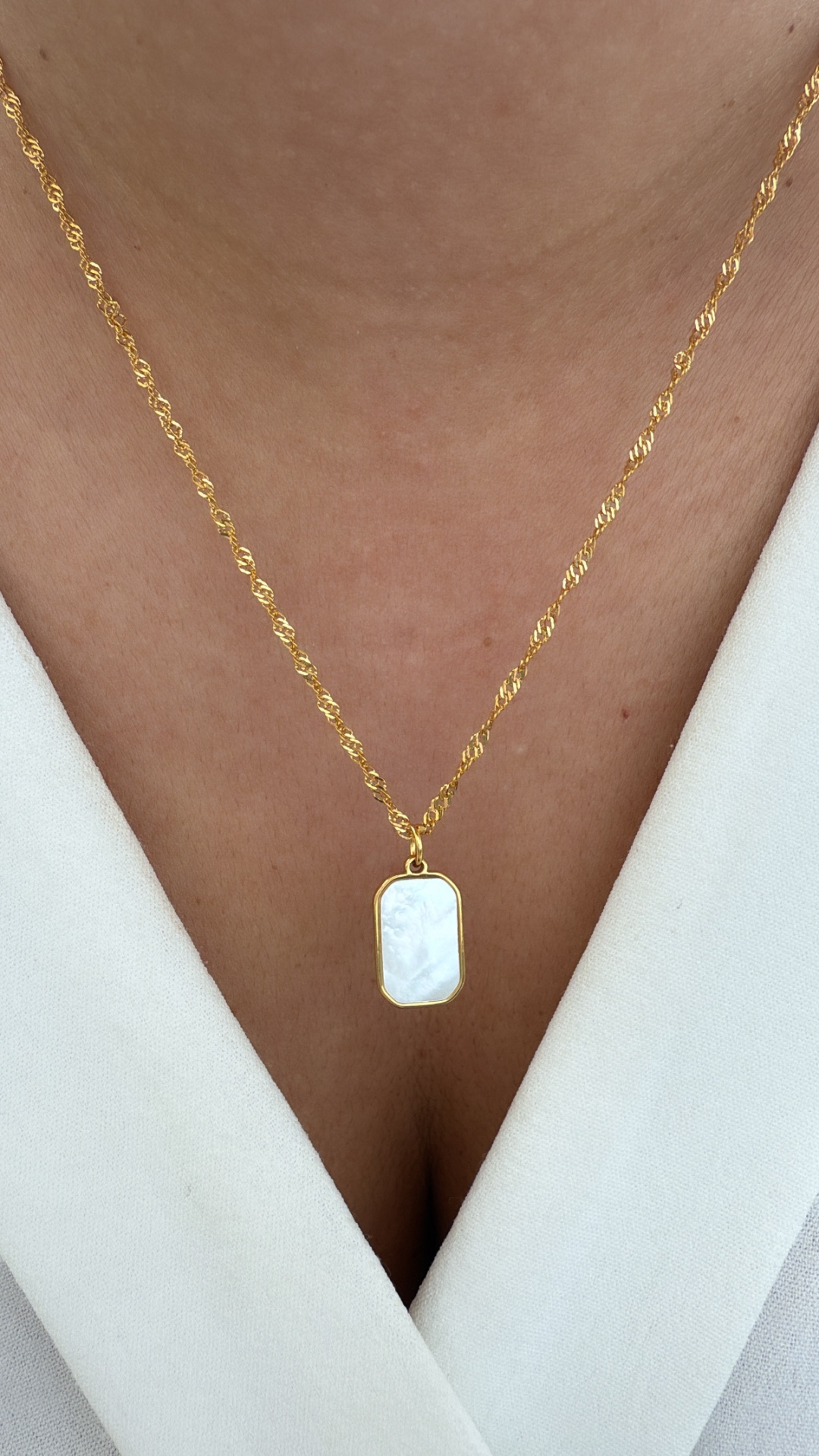 Colar dourado com pendente branco nacarado