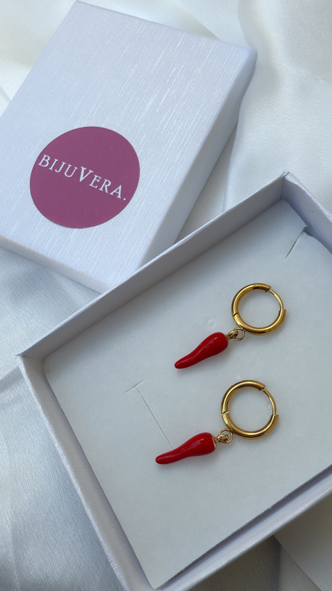 brincos dourados com pendentes de pimento vermelho em caixa branca com logo BIJUVERA