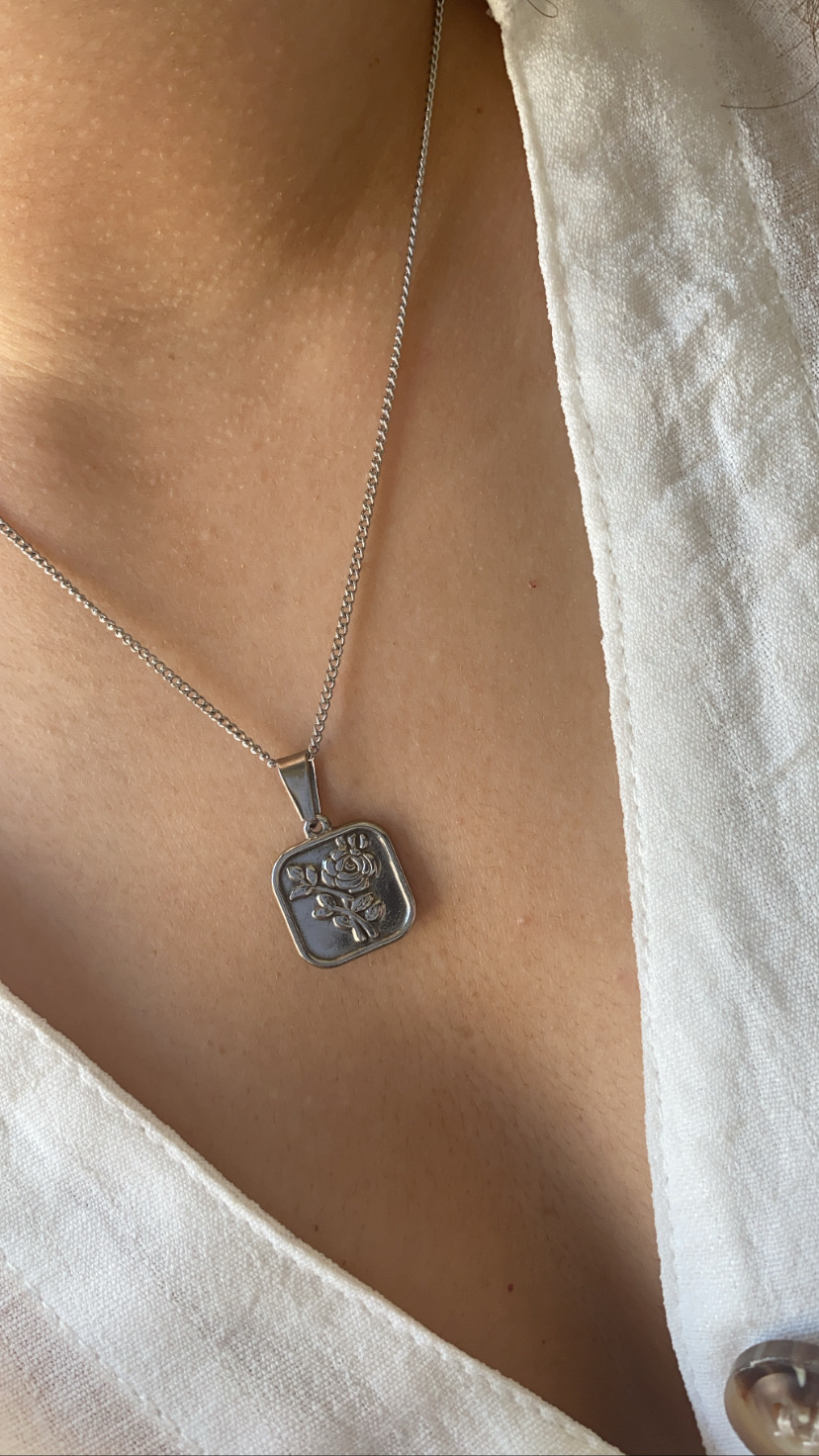 Colar prateado com pendente quadrado com rosa em relevo