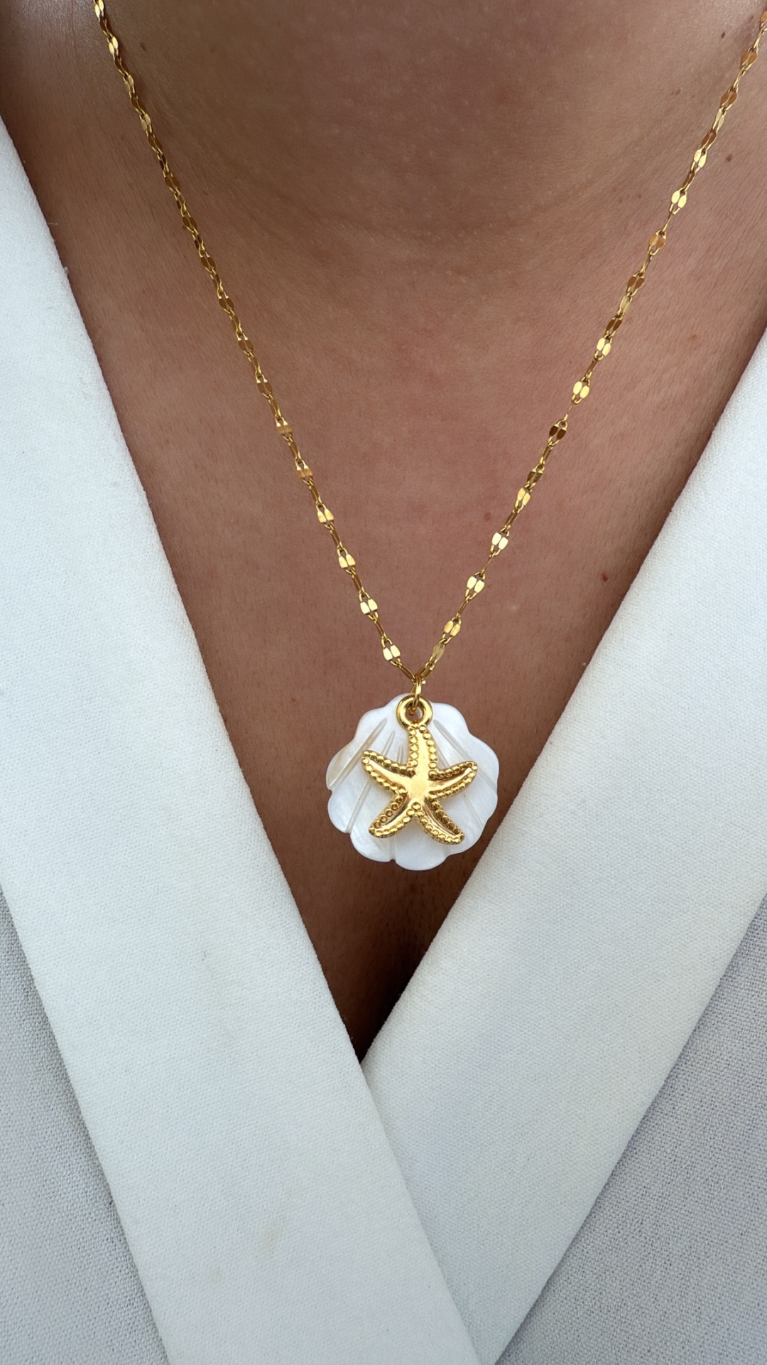 Colar dourado com pendente de concha e estrela-do-mar