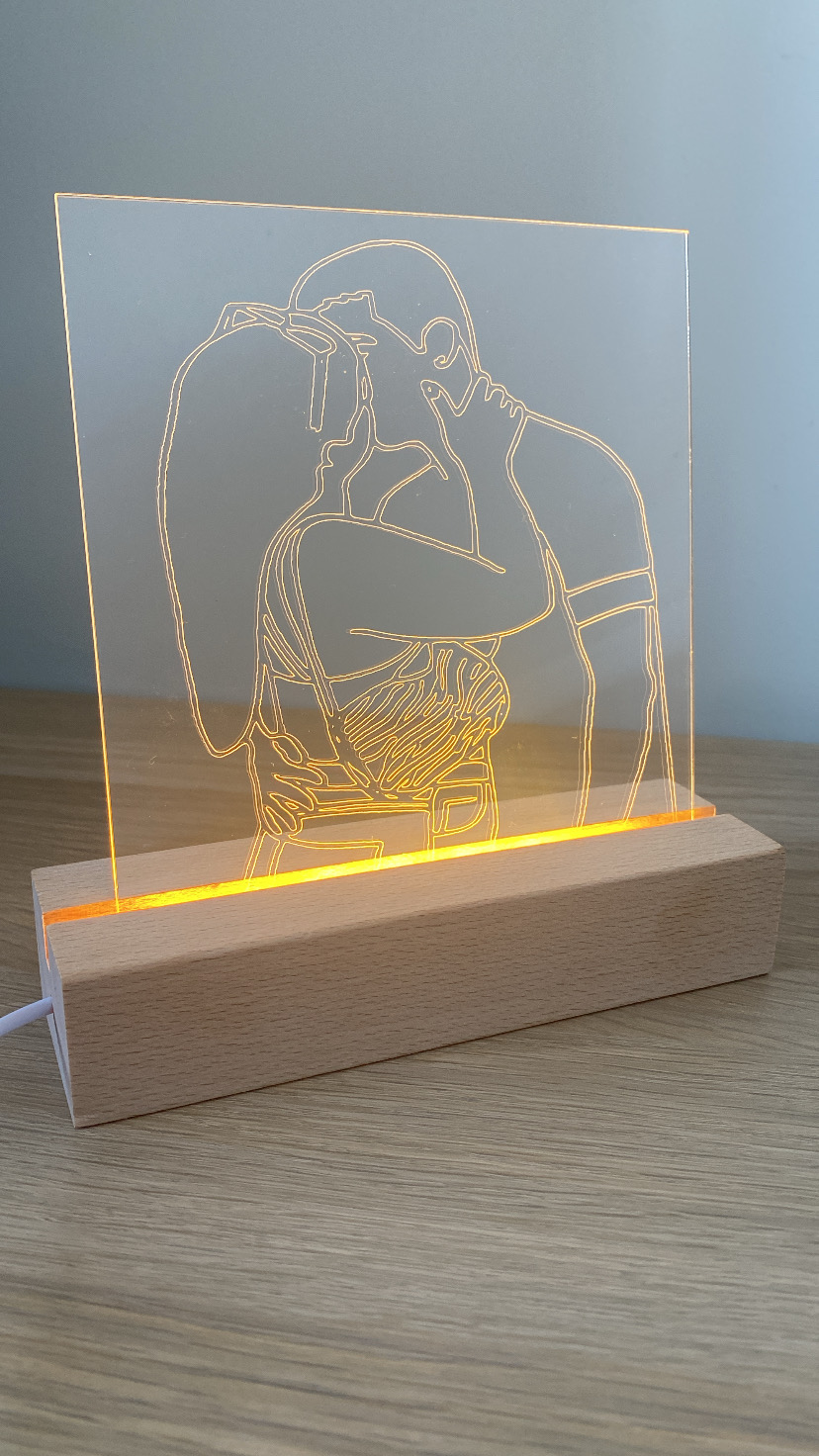 Luminária decorativa com desenho de casal a beijar-se iluminado